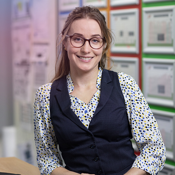 ABP staff member in an office environment smiling to camera