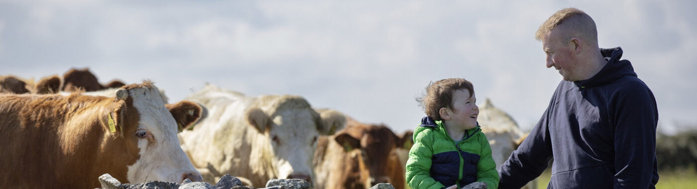 ABP farmer with his son sitting on a stone wall